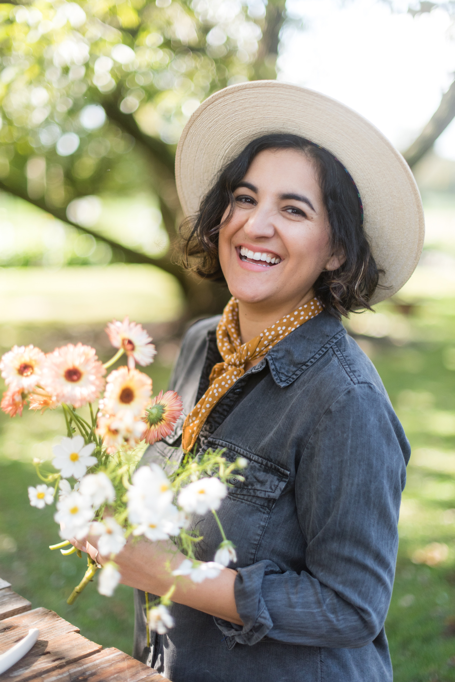 Amy Balsters smiles as she holds a bouquet of field flowers to reference how to find floral color palette inspiration beyond the color wheel.
