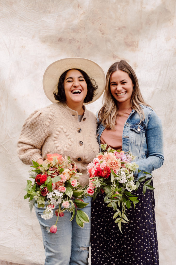 Amy Balsters posing with one of her student florists from the floral arrangement class while holding up their work; photo by @karenobrist