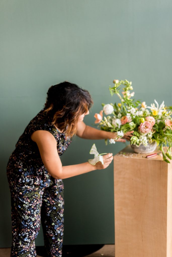 Amy Balsters placing a flower into a centerpiece.